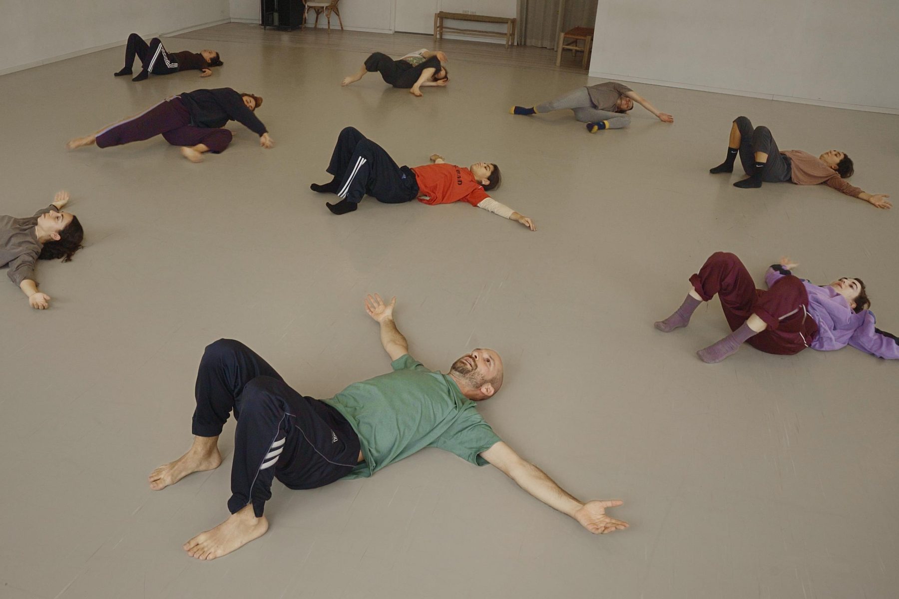 Tal and students lying on the studio floor during class
